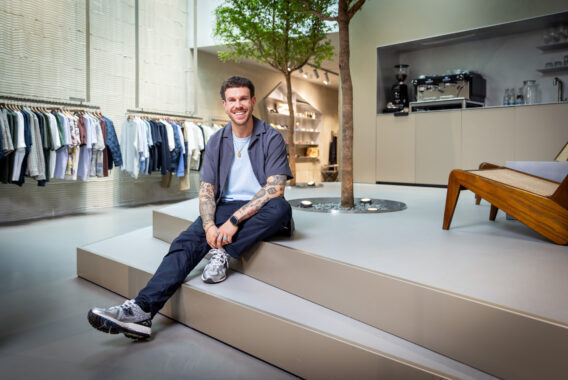 Man zit op een verhoging in een moderne kledingwinkel.